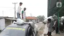 Pekerja mengangkut barang dari perahu menuju mobil bak terbuka di Desa Pantai Mekar, Muaragembong, Kabupaten Bekasi, Senin (6/12/2021). Jasa angkut barang menggunakan perahu tersebut bertarif Rp 3.000 per 15 kg. (Liputan6.com/Herman Zakharia)