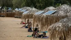 Panel surya terpasang pada sejumlah payung di pantai dekat Balai Kota Vari-Voula-Vouliagmeni, Yunani, Selasa (21/7/2020). Puluhan payung di sepanjang pantai tersebut dilengkapi sistem panel surya dan port USB untuk menyediakan pengisian daya gratis dan ramah lingkungan. (Xinhua/Lefteris Partsalis)