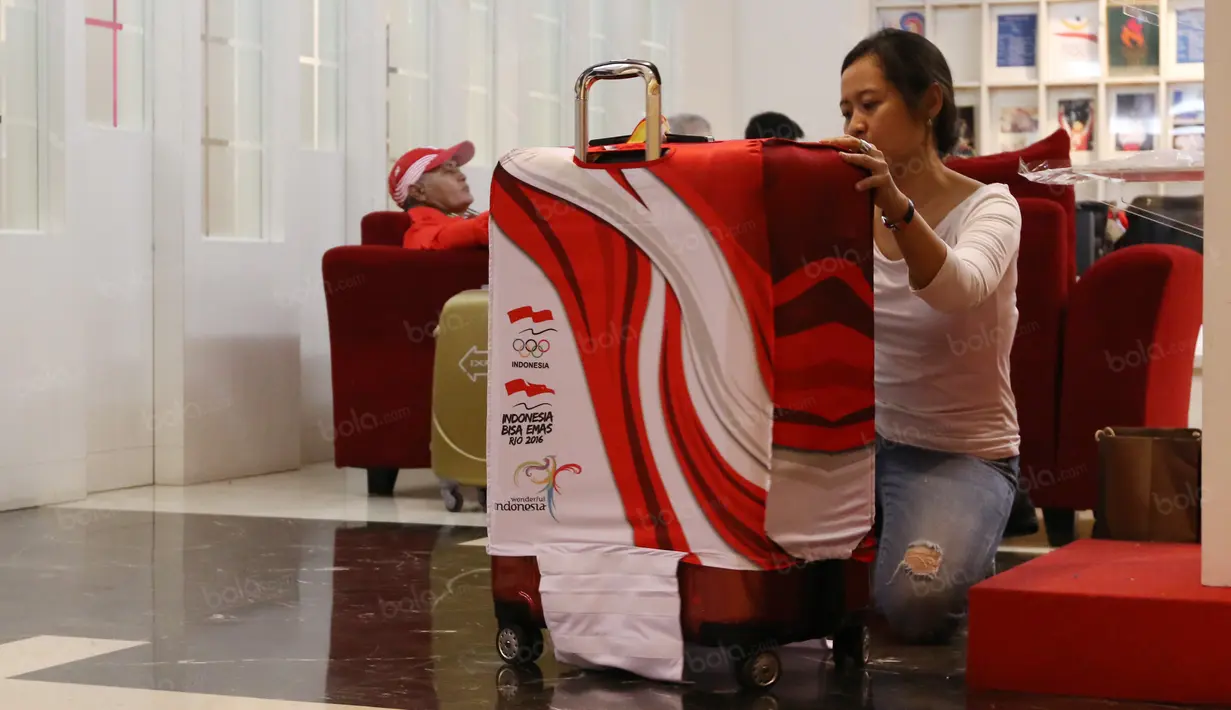 Seorang Official sedang merapikan koper atlet sebelum berangkat ke Olimpiade Rio 2016 di Kantor KOI, Jakarta. Rabu (27/7/2016). (Bola.com/Nicklas Hanoatubun)