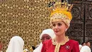 Dalam prosesi ini Anisha Rosnah tampil serba merah dengan busana khas perempuan Brunei. Ia dibalut baju kurung lengan panjang, dipadukan kain Jong yang dibuat seperti obi serta sabuk keemasan. [@british.hc.bn]