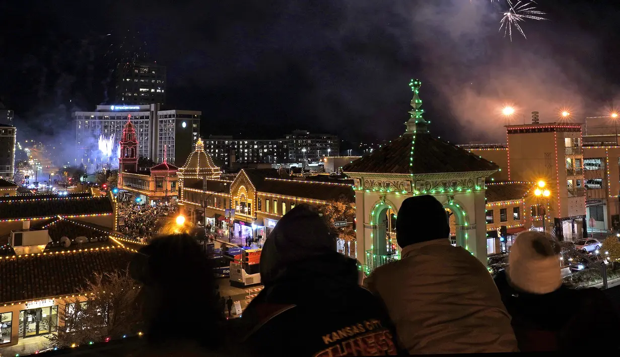 Orang-orang menonton lampu Natal dinyalakan di distrik perbelanjaan Country Club Plaza, Kansas City, Missouri, Amerika Serikat, 25 November 2021. Upacara malam Thanksgiving ini menampilkan lebih dari 200.000 lampu yang mencakup area 15 blok. (AP Photo/Charlie Riedel)