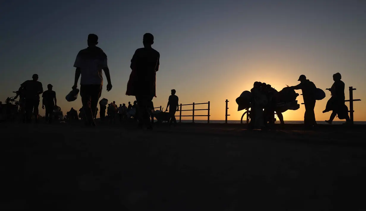 Pengungsi Palestina yang terpaksa mengungsi kembali bergerak menuju wilayah selatan di sepanjang jalan di kawasan kamp pengungsi Nuseirat di Jalur Gaza tengah pada 20 September 2025. (Eyad BABA/AFP)