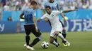 Pemain Arab Saudi, Taiseer Aljassam (tengah) berusaha melewati adangan pemain Uruguay, Guillermo Varela pada laga grup A Piala Dunia 2018 di Rostov Arena, Rostov-on-Don, Rusia, (20/6/2018). Uruguay menang 1-0. (AP/Darko Vojinovic)