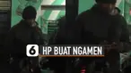 Ada-ada saja yang dilakukan oleh pria ini ketika mengamen karena menggunakan handphone saat memainkan alat musik.
