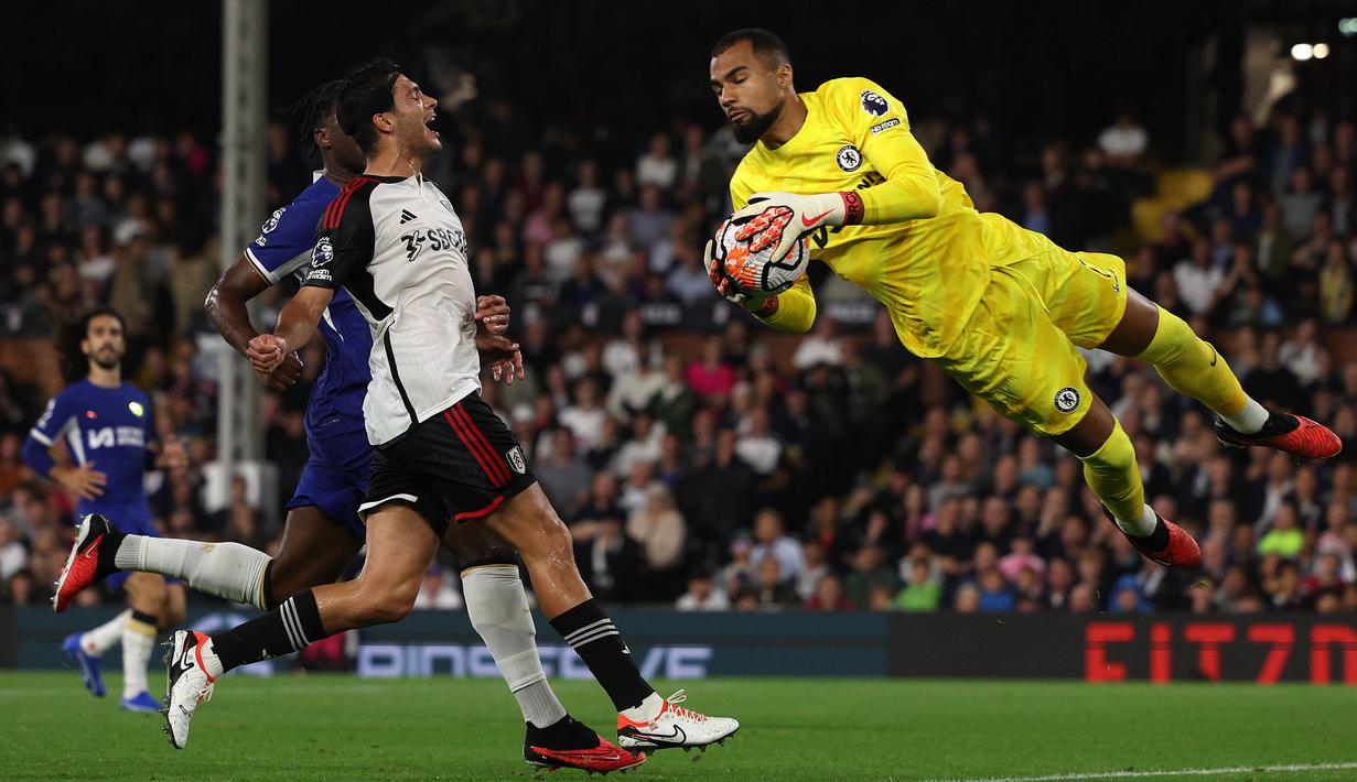 Penjaga gawang Chelsea, Robert Sanchez (kanan), berhasil mengamankan bola dari serangan pemain Fulham dalam pertandingan pekan ketujuh Liga Inggris 2023/2024 yang digelar di Craven Cottage, Selasa (3/10/2023) dini hari WIB. (AFP/Adrian Dennis)