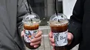 Gambar pada 26 Januari 2023 ini menunjukkan orang-orang memegang es Americano selama wawancara dengan AFP di sebuah jalan di Seoul. Kopi sederhana -- segelas espresso yang disajikan di atas es, ditambag dengan air -- telah menjadi minuman nasional tidak resmi Korea Selatan, melebihi penjualan rekannya yang panas bahkan selama musim dingin yang mengigit, data Starbucks menunjukkan. (Jung Yeon-je / AFP)