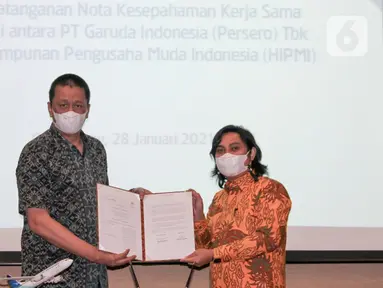 Direktur Utama Garuda Indonesia, Irfan Setiaputra (kiri) bersama Ketua Umum HIPMI, Mardani H Maming menunjukkan Nota Kesepahaman Corporate Sales, usai ditandatangani di Garuda City Center, Tangerang, Banten, Kamis (28/01/2021). (Liputan6.com/HO/Wedi)