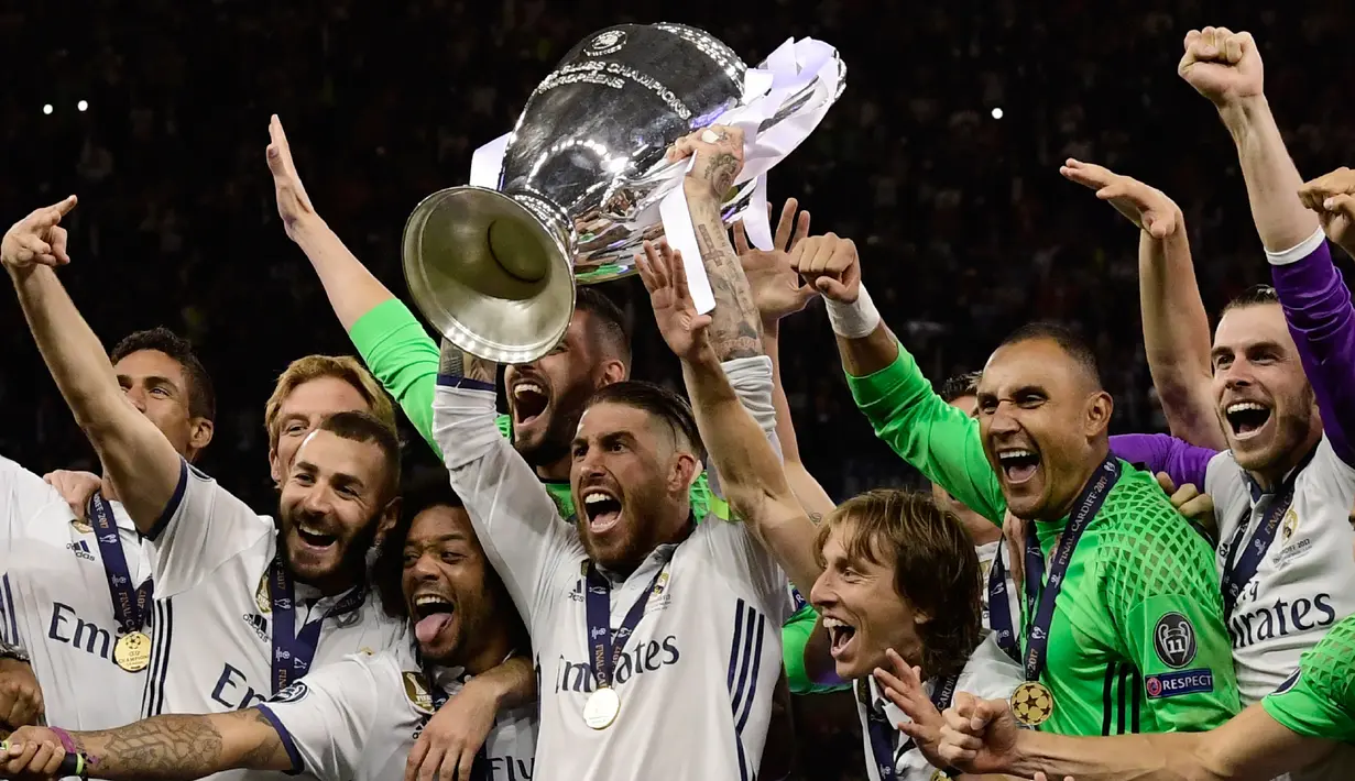 Kapten Real Madrid, Sergio Ramos mengangkat trofi bersama timnya usai memenangkan pertandingan Liga Champions di Stadion Cardiff, Wales (3/6). (AFP Photo/Javier Soriano)
