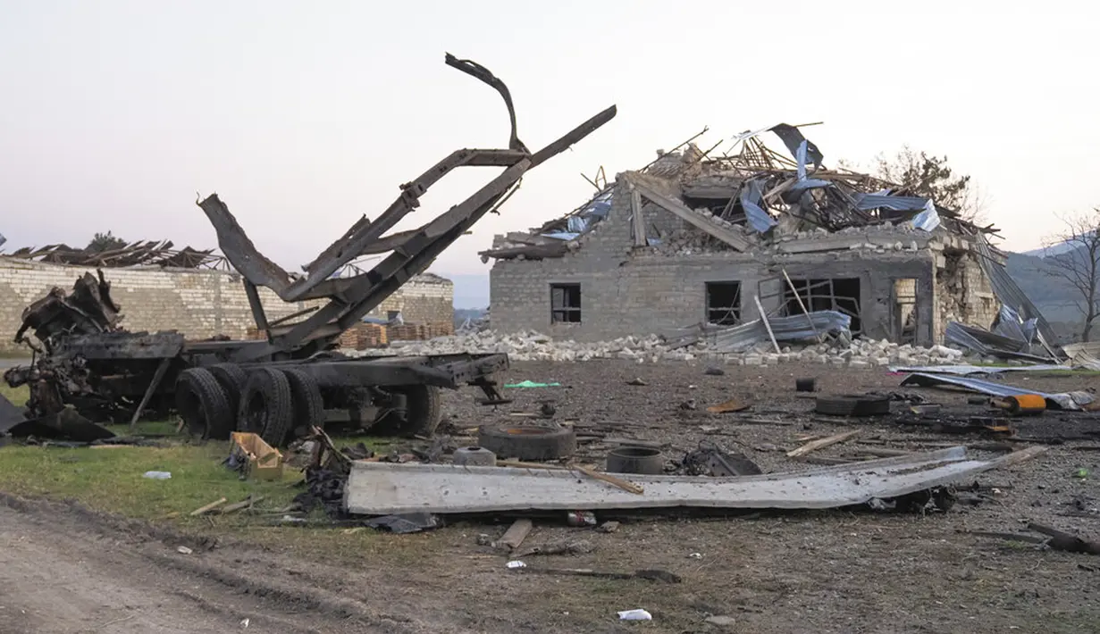 Sebuah bangunan dan kendaraan hancur setelah penembakan oleh artileri Azerbaijan selama konflik militer dengan Armenia di luar Stepanakert, wilayah separatis Nagorno-Karabakh, Senin (19/10/2020). Pertempuran di Nagorno-Karabakh berkecamuk selama lebih dari tiga minggu. (AP Photo)