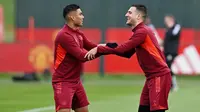 Pemain Manchester United, Casemiro dan Diogo Dalot, tampak bercanda saat sesi latihan di Carrington Training Complex, Senin (23/10/2023). (AFP/Paul Ellis)