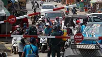 Orang-orang diblokir oleh petugas polisi setempat untuk masuk ke jalan kota utama dekat bandara Internasional Phnom Penh di Phnom Penh, Kamis (15/4/2021). Pemimpin Kamboja memutuskan untuk lockdown Phnom Penh selama dua minggu menyusul kenaikan tajam kasus COVID-19. (AP Photo/Heng Sinith)
