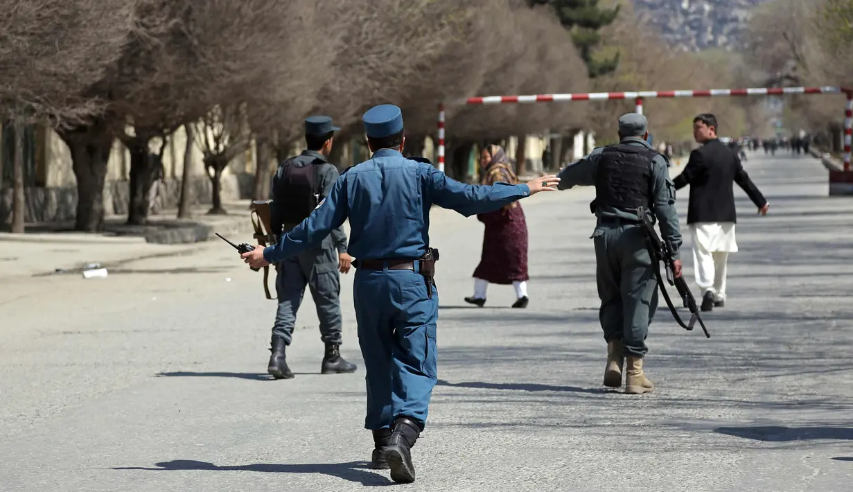 Pasukan keamanan memblokir jalan di lokasi serangan bunuh diri di depan Universitas Kabul, Afghanistan, (21/3). Pejabat Afghanistan melaporkan ledakan tersebut di saat warga merayakan Tahun Baru Persia. (AP Photo/Rahmat Gul)