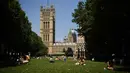 Orang-orang bersantai di bawah sinar matahari di Victoria Tower Gardens dekat Gedung Parlemen di London (23/7/2019). Suhu melonjak di atas 30C (86F) di Inggris pada 23 Juli dengan para peramal cuaca memperkirakan suhu setinggi 37C (96.8F) sebelum akhir pekan. (AFP Photo/Ben Stansall)