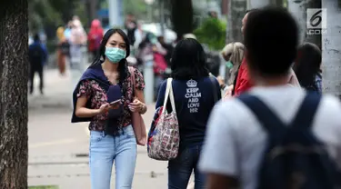 Warga berjalan di pedestrian di kawasan Jalan Jenderal Sudirman, Jakarta, Jumat (14/7). Kepala Dinas LHK DKI Jakarta Isnawa Adji menjelaskan selain masalah sampah dan sungai, pihaknya juga fokus pada kualitas udara. (Liputan6.com/Helmi Fithriansyah)