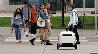 Robot pengantar makanan melintasi jalan di Ann Arbor, Michigan pada Kamis, 7 Oktober 2021. (Foto: AP/Carlos Osorio)