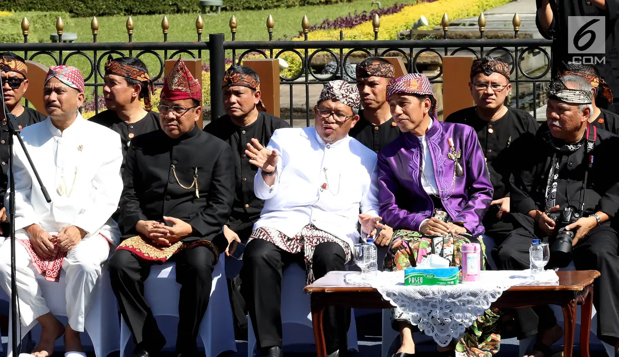 Presiden Joko Widodo (Jokowi) berbincang dengan Gubernur Jawa Barat, Ahmad Heryawan dalam acara Karnaval Kemerdekaan Pesona Parahyangan di Bandung,  Sabtu (26/8). Jokowi mengenakan baju adat Sunda dengan dominasi warna ungu. (Liputan6.com/Johan Tallo)