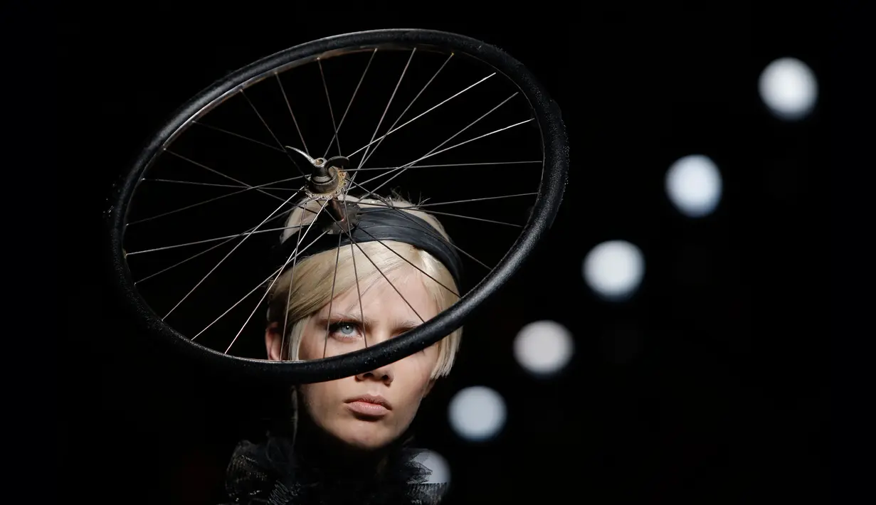 Model mengenakan busana rancangan Moschino dengan hiasan kepala berbentuk roda sepeda dalam Milan Fashion Week Autumn/Winter 2017 di Milan, Italia, (23/2). (AFP Photo / Marco Bertorello)