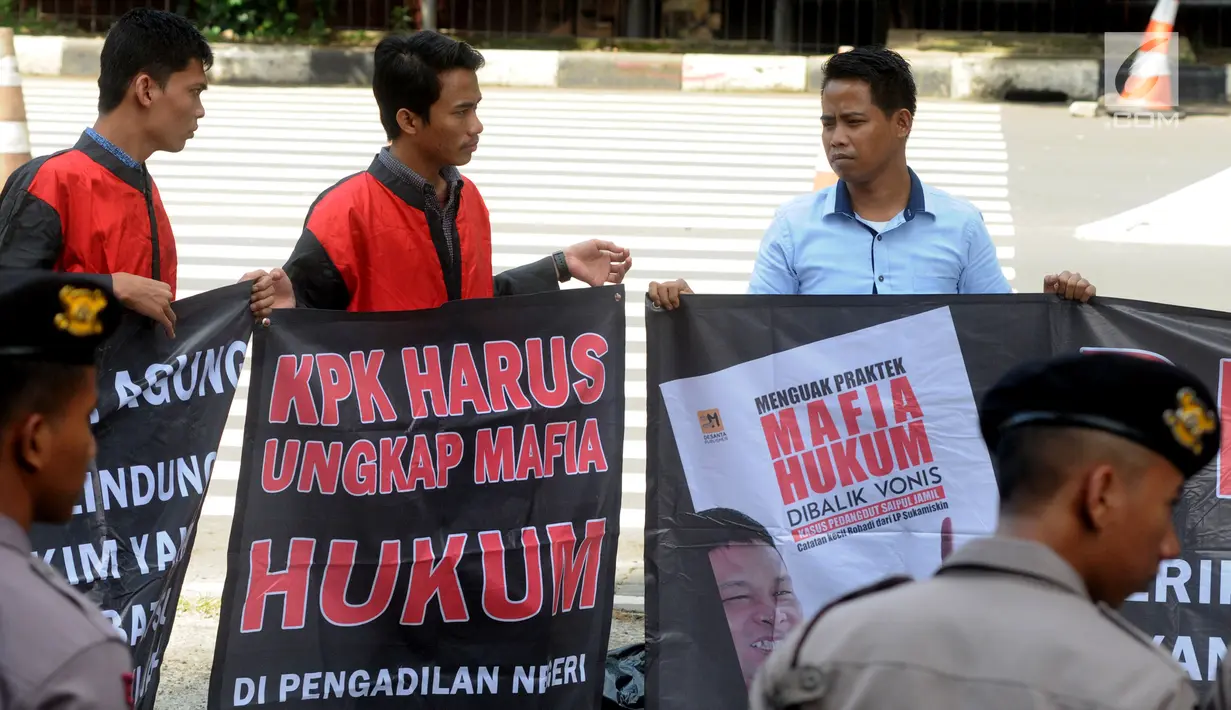 Masyarakat Peduli Keadilan membentangkan spanduk saat berunjuk rasa di depan Gedung KPK, Jakarta, Senin (4/2). Massa mendesak KPK memeriksa mafia hukum kasus suap eks Panitera PN Jakut Rohadi atas peringanan vonis Saipul Jamil. (Merdeka.com/Dwi Narwoko)