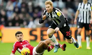 Pemain Newcastle United, Lewis Hall, terjatuh saat berebut bola dengan pemain Nottingham Forest, Morgan Gibbs-White, dalam lanjutan Liga Inggris di St James Park, Selasa (26/12/2023). (AFP/Andu Buchanan)