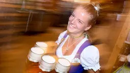 Pelayan wanita membawa gelas bir untuk pengunjung Oktoberfest di tempat peristirahatan Theresienwiese di Munich, Jerman selatan (24/9). Festival bir terbesar di dunia ini berlangsung sampai 3 Oktober 2017. (AFP Photo/dpa/Tobias Hase/Germany Out)