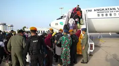 Tentara membantu warga negara Indonesia (WNI) menaiki Boeing 737 TNI AU sebelum dievakuasi dari Port Sudan ke kota Jeddah di Saudi pada 27 April 2023. (Handout/Indonesian Armed Forces (TNI)/AFP)