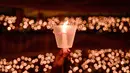 Dari tema itu pula, banyak doa-doa yang dipanjatkan jemaat Gereja Bethany Nginden Surabaya di momen Natal tahun ini. Tampak dalam foto, seorang umat Kristiani memegang lilin selama misa Hari Natal di Gereja Bethany, Surabaya, Jawa Timur pada Kamis 25 Desember 2025. (JUNI KRISWANTO/AFP)