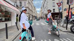 Luna Maya bersama temannya saat bersiap berkeliling kota Paris menggunakan sepeda. Ia tampil cantik mengenakan Kaos dan topi putih dengan membawa tas Hermes. (Instagram/lunamaya)