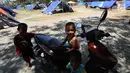 Senyum anak-anak pengungsi korban gempa dan tsunami Palu di lapangan Masjid Agung Daru Salam, Palu, Sulteng, Jumat (5/10). Pemindahan pengungsi dari tenda ke barak oleh pemerintah untuk mempercepat penanganan pascagempa. (Liputan6.com/Fery Pradolo)