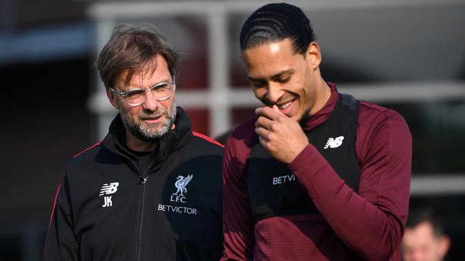 Pelatih Liverpool, Jurgen Klopp, berbincang dengan Virgil van Dijk saat sesi latihan jelang laga Liga Champions di Melwood, Liverpool, Senin (8/4). Liverpool akan berhadapna dengan Porto. (AFP/Paul Ellis)