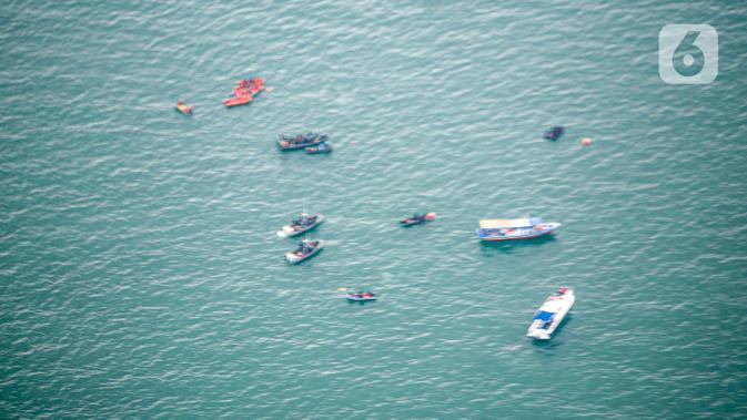Foto dari udara memperlihatkan tim gabungan melakukan proses pencarian pesawat Sriwijaya Air SJ 182 yang hilang kontak di sekitar perairan Kepulauan Seribu, Jakarta, Minggu (10/1/2021). Dari pantauan udara terlihat tumpahan minyak yang diduga milik Sriwijaya Air SJ 182. (Liputan6.com/Faizal Fanani)
