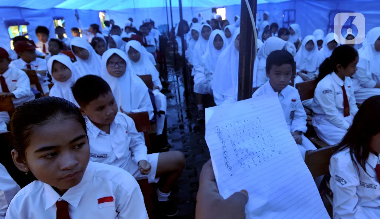 Murid-murid mengikuti kegiatan belajar di dalam tenda darurat di SDN Cirimekar 2, Cibinong, Bogor, Senin (6/1/2020). Hari ini merupakan hari pertama murid sekolah melakukan kegiatan belajar mengajar (KBM) paska libur tahun baru dan bencana banjir yang melanda kawasan Jabotabek. (merdeka.com/Arie Bas