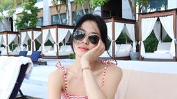 Detail pita pada tali bahunya mempercantik kesan femininnya, sementara memadukannya dengan topi bisbol dan kacamata hitam bundar menciptakan tampilan yang stylish. (Foto: Instagram/ kyo1122)