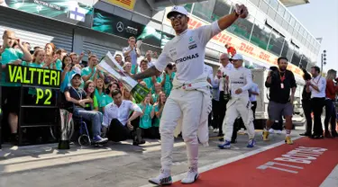 Lewis Hamilton merayakan kemenangannya dalam balapan F1 GP Italia, di arena Monza, Italia (3/9). Hamilton keluar sebagai juara pada balapan F1 GP Italia dengan keunggulan 4,4 detik atas Valtteri Bottas yang finis kedua. (AP Photo/Luca Bruno)