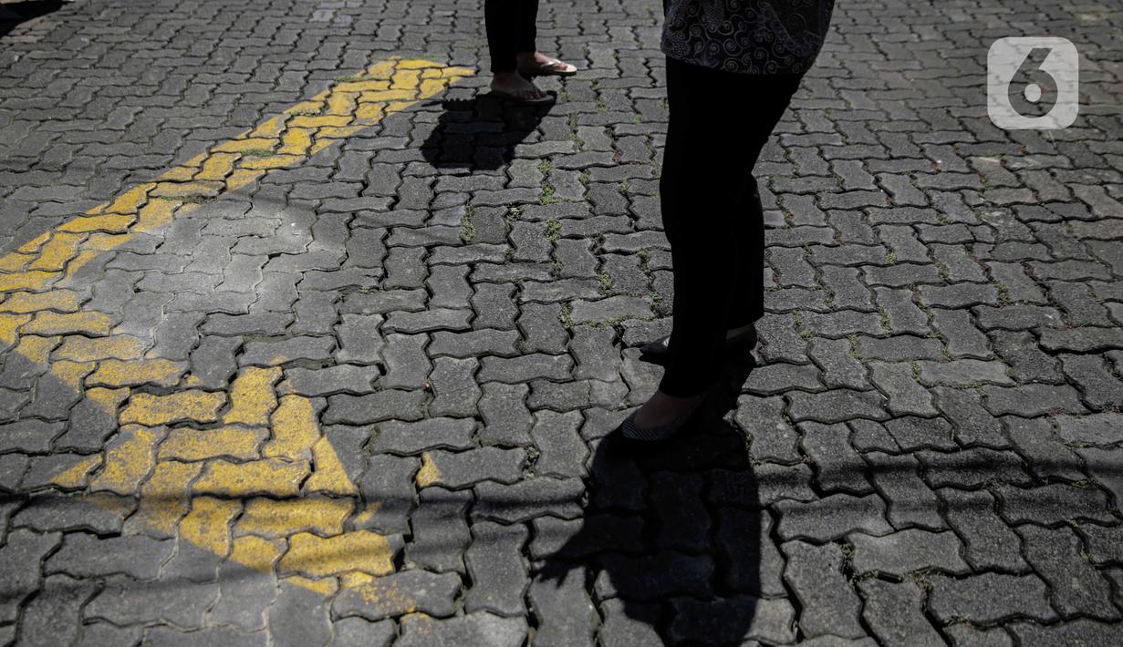 Sejumlah pegawai berjemur di bawah sinar matahari di Kawasan Fatmawati, Jakarta, Selasa (31/3/2020). Berjemur diri di bawah sinar matahari saat pagi merupakan salah satu upaya yang paling sederhana untuk menjaga kesehatan selama wabah virus COVID-19. (Liputan6.com/Faizal Fanani)