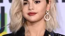 Penyanyi Selena Gomez berpose untuk fotografer di karpet merah American Music Awards 2017 di Microsoft Theatre, Los Angeles, Minggu (19/11). Wanita 25 tahun tersebut untuk pertama kalinya mencat rambutnya dengan warna pirang. (Jordan Strauss/Invision/AP)
