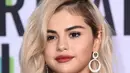 Penyanyi Selena Gomez berpose untuk fotografer di karpet merah American Music Awards 2017 di Microsoft Theatre, Los Angeles, Minggu (19/11). Wanita 25 tahun tersebut untuk pertama kalinya mencat rambutnya dengan warna pirang. (Jordan Strauss/Invision/AP)