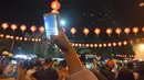 Warga mengambil gambar kembang api yang meluncur di kawasan Pasar Gedhe Surakarta saat perayaan Imlek, Surakarta, Sabtu (28/01). Grebeg Soediro adalah  tradisi  tahunan alkuturasi  budaya  Jawa dan  Cina. (Liputan6.com/Gholib)  