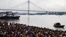 Ratusan umat Hindu melakukan ritual 'Tarpan' mempersembahkan doa kepada leluhur mereka pada hari terakhir Pitrupaksh di tepian Sungai Gangga di Kolkata (19/9). Dalam mitologi Hindu Hari Pitrupaksh juga disebut 'Mahalaya'. (AFP Photo/Dibyangshu Sarkar)
