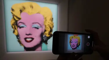 Jurnalis mengambil foto lukisan "Shot Sage Blue Marilyn" karya Andy Warhol selama pratinjau pers di New York, Senin (21/3/2022).  Rumah lelang Christie menyatakan akan melelang lukisan potret Marilyn Monroe yang dibuat Warhol pada 1964 tersebut pada Mei mendatang di New York. (TIMOTHY A. CLARY/AFP)