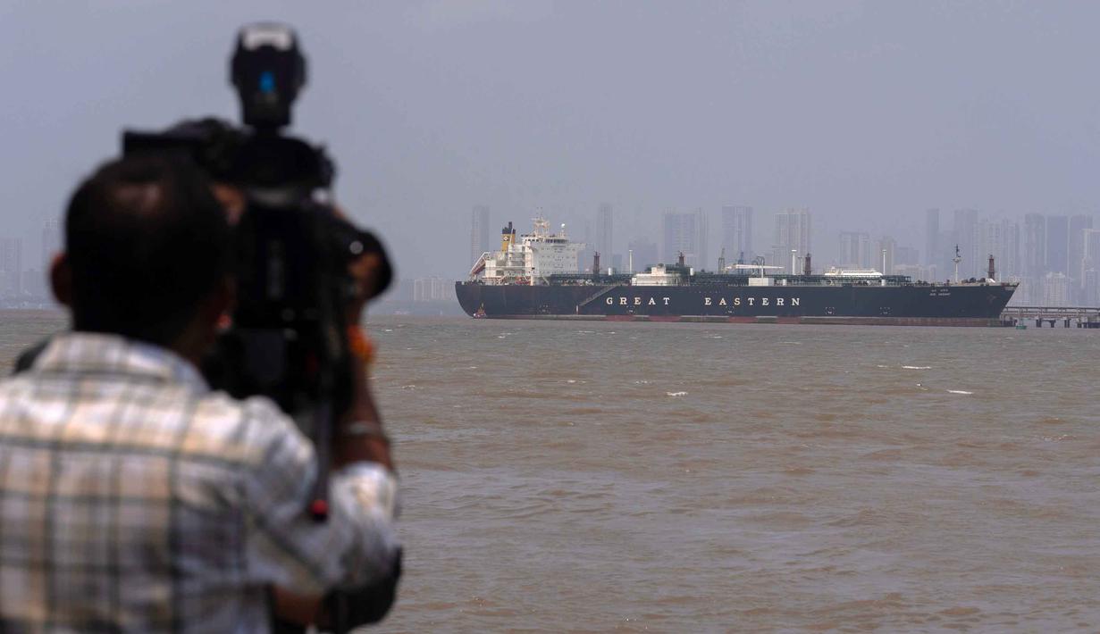 Selat ini menghubungkan Teluk Persia dengan Oman dan Laut Arab, menjadikannya sebagai urat nadi vital bagi 20% pasokan minyak dan gas global. Tampak dalam foto, seorang juru kamera merekam kapal pengangkut Liquefied Petroleum Gas (LPG) berbendera India, Jag Vasant, yang mengangkut gas minyak cair di Pelabuhan Mumbai, India, setelah kapal tersebut melewati Selat Hormuz, Rabu, 1 April 2026. (AP Photo/Rafiq Maqbool)