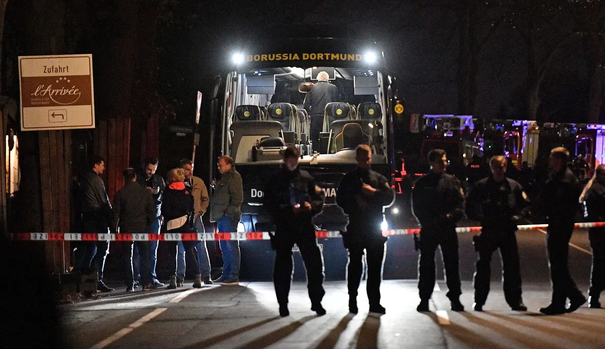 Polisi berjaga di depan bus tim Borussia Dortmund yang rusak terkena ledakan bom di Dortmund, Jerman Barat, Selasa (11/4). Bus membawa pemain Borussia Dortmund untuk pertandingan perempat final Liga Champions melawan Monaco. (AP Photo/Martin Meissner)