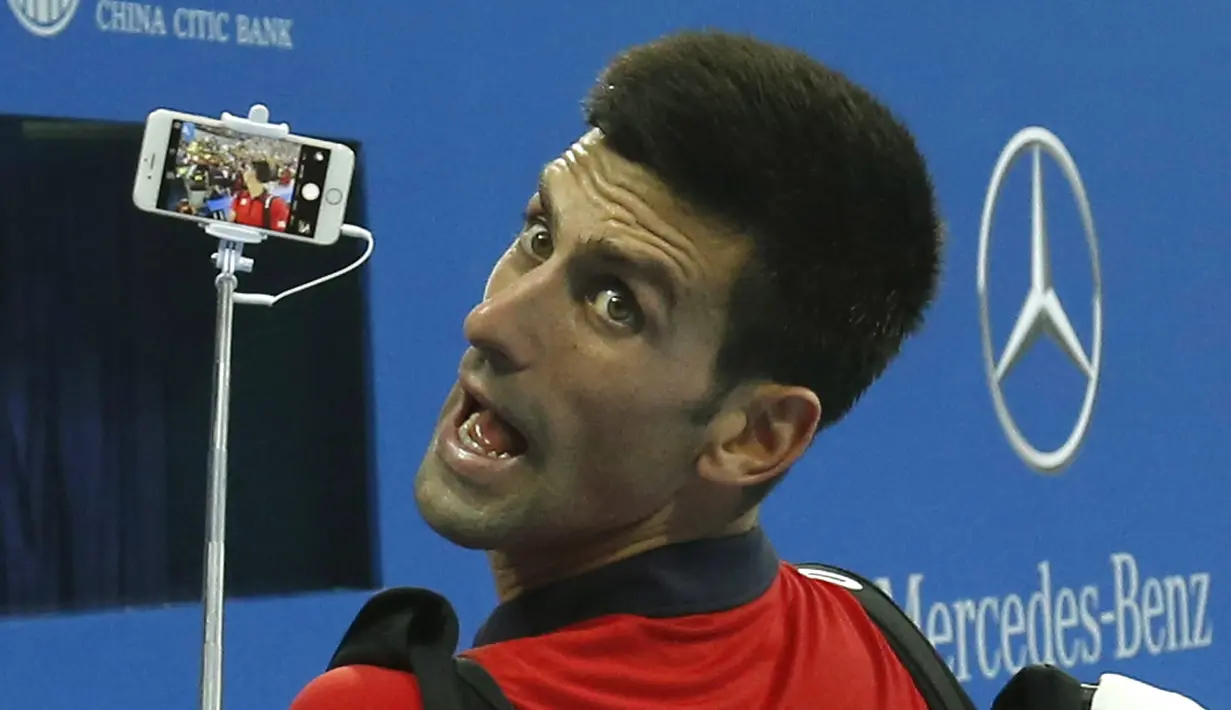 Petenis  Novak Djokovic melakukan selfie bersama fans usai mengalahkan petenis Italia Simone Bolelli di China Open tennis tournament, Beijing, China, Selasa (06/10/2015).  (REUTERS/Kim Kyung-Hoon)