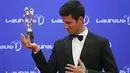 Novak Djokovic  berfoto dengan trofi yang diraihnya pada ajang penghargaan Laureus World Sports Awards 2016, Berlin, Germany, (18/4/2016).  Djokovic terpilih sebagai Laureus World Sportsman of the Year. (REUTERS/Hannibal Hanschke)