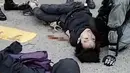 Demonstran prodemokrasi terbaring setelah ditembak oleh seorang polisi saat terjadi protes di Distrik Sai Wan Ho, Hong Kong, Senin (11/11/2019). Hingga kini belum diketahui kondisi demonstran yang ditembak oleh polisi tersebut. (STRINGER/CUPID NEWS/AFP)