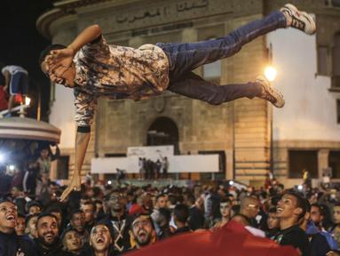 Warga Maroko berpesta merayakan keberhasilan negaranya lolos ke Piala Dunia 2018 di Rabat, Sabtu (11/11/2017). Maroko lolos setelah mengalahkan Pantai Gading 2-0 pada laga penentu. (AP/Mosa'ab Elshamy)