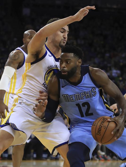 Pemain Memphis Grizzlies, Tyreke Evans (12) mencoba melewati adangan pemain Golden State Warriors, Klay Thompson pada laga NBA basketball games di ORACLE Arena, Oakland (20/12/2017). Warriors menang 97-84. (AP/Ben Margot)