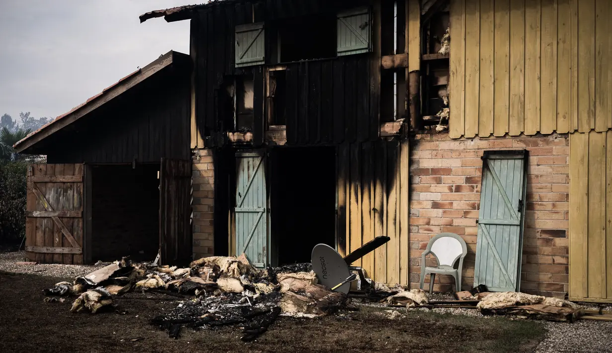 Sebuah rumah yang terbakar oleh kebakaran hutan di Saumos, pinggiran barat Bordeaux, barat daya Prancis (13/9/2022). Kebakaran yang berlangsung sejak 12 September 2022 telah menyebar sekitar 1800 hektar vegetasi dan hutan di Saumos dan memaksa evakuasi kota dalam konteks suhu tinggi di Gironde. (AFP/Philippe Lopez)