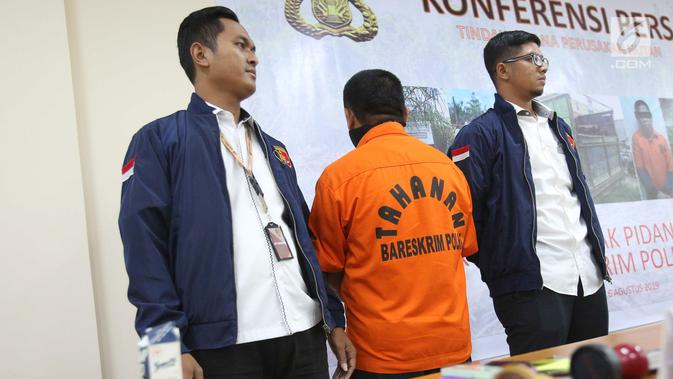 Polisi menghadirkan tersangka saat rilis kasus tindak pidana illegal loging di Bareskrim Polri, Jakarta, Selasa (6/8/2019). Tersangka berinisial M ditangkap karena menjadi dalam pembalakan liar hutan di Provinsi Jambi dan Sumatera Selatan. (Liputan6.com/Immanuel Antonius)