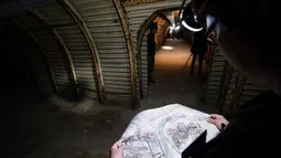 Seorang Pengunjung melihat peta saat menelusuri terowongan Fan Bay Deep Shelter, tepat di bawah White Cliffs of Dover, Inggris, Kamis (23/7/2015). Terowongan ini diciptakan oleh Perdana Menteri Inggris Winston Churchill 1940. (AFP/Leon Neal)