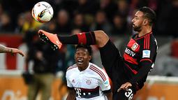 Gelandang Leverkusen, Karim Bellarabi, berusaha melewati bek sayap Bayern Munchen, David Alaba. Meski imbang, hasil ini tidak menggoyahkan Munchen di puncak klasemen Bundesliga. (AFP/Patrik Stollarz)